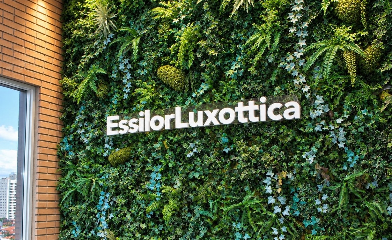 Espaço de convivência com jardim vertical e o logo EssilorLuxottica