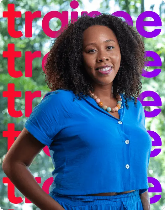 Mulher, colaboradora da Globo, negra com cabelo cacheado, usando um colar colorido e roupas azuis.